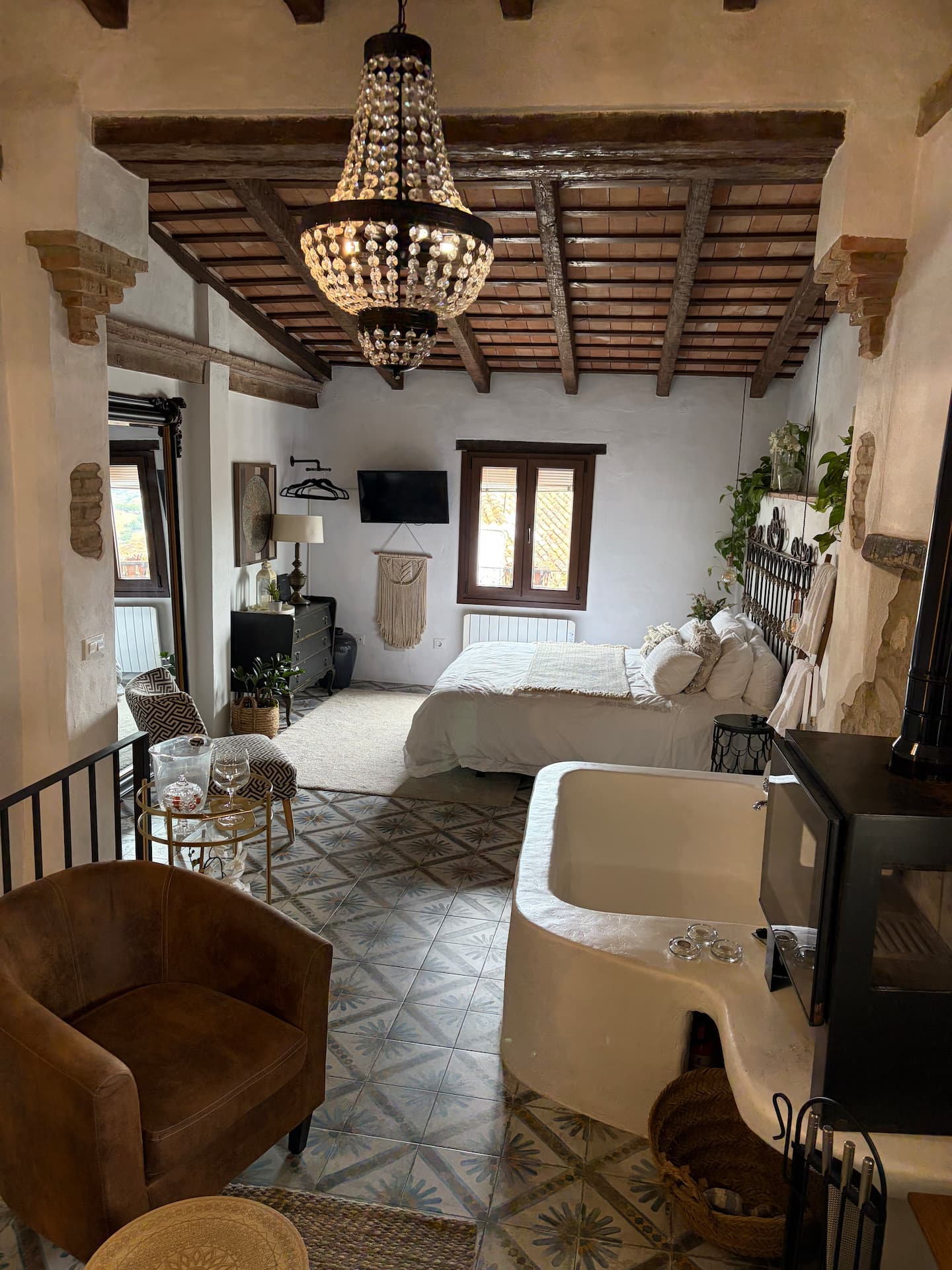 Vista real de la bañera, el dormitorio y las vigas de madera de la casa