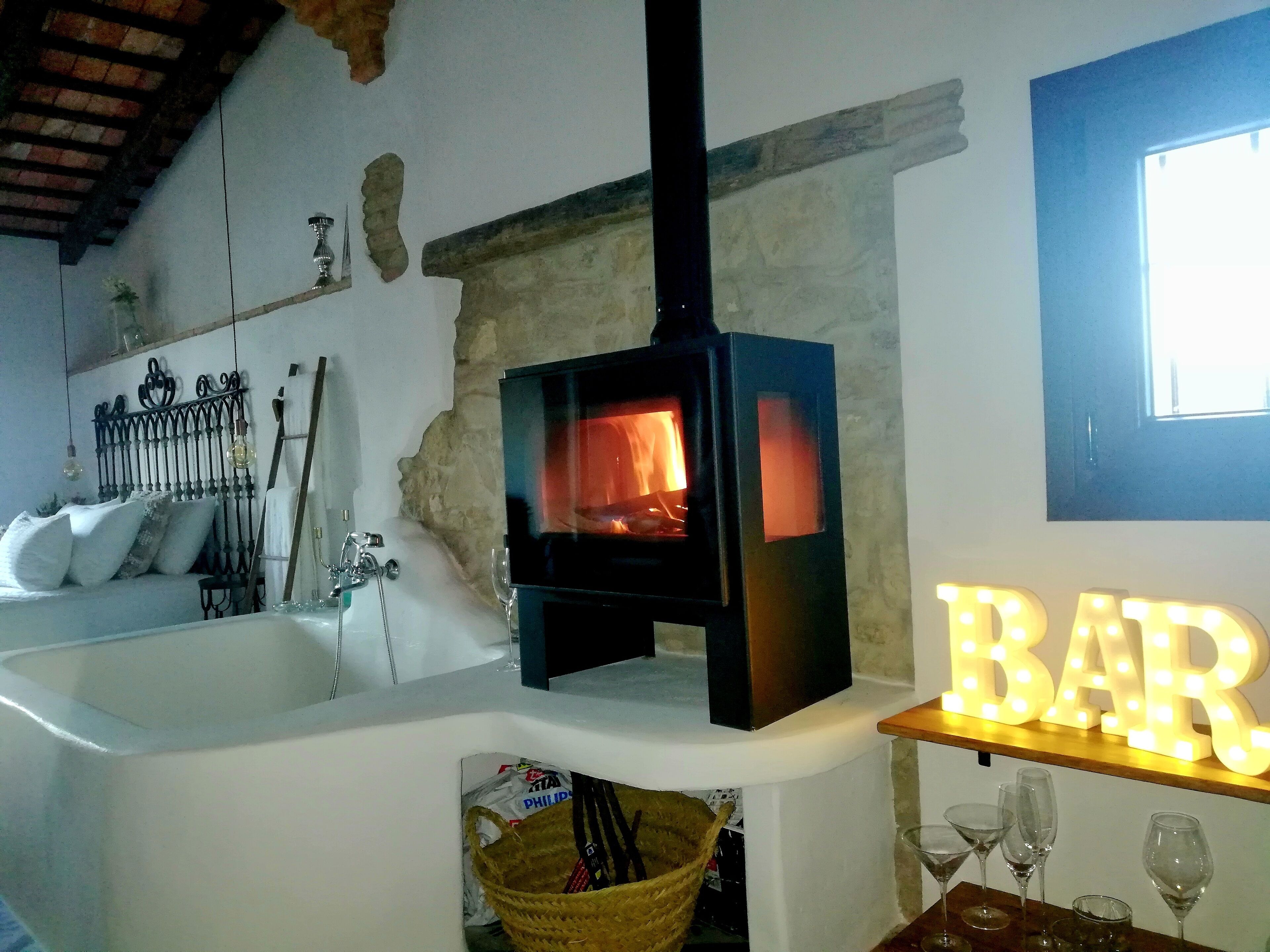 El fuego de la chimenea junto a la bañera y al dormitorio